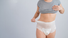 Woman In Adult Diapers On A White Background. Incontinence Problem.