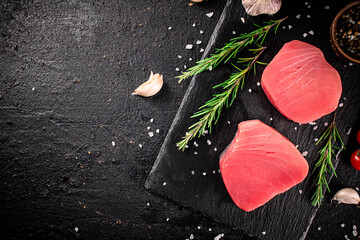 Sticker - Raw tuna on a stone board with rosemary and garlic. 