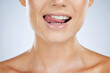 Woman, closeup and smile with tongue in studio for beauty, skincare and face by grey by background. Model, healthy mouth and teeth whitening with dental wellness, health and self care for aesthetic