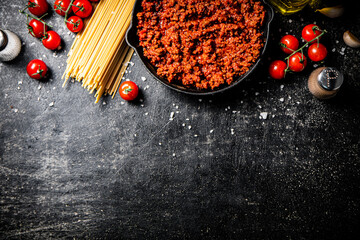 Wall Mural - Bolognese sauce in a pan with tomatoes, and pasta dry. 