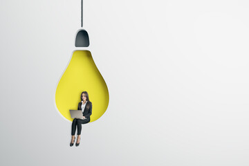 Wall Mural - Start up, business and creative idea concept with sitting in light wall background hole in form of yellow light bulb businesswoman with laptop