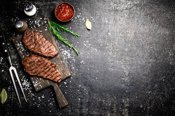 Wall Mural - Grill steak on a wooden cutting board.