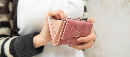 Young woman holding empty wallet. No Money