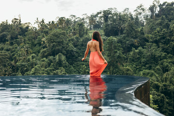 Wall Mural - Female standing in swimming pool at luxury resort