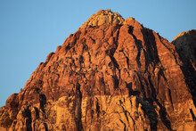 Lever De Soleil Sur Red Rock Mountain, Las Vegas, Nevada, États-Unis D'Amérique. Montagne à La Roche Rouge Et Jaune S'élevant Au Milieu D'une Plaine Aride De Cailloux Et De Sable Poussiéreux.