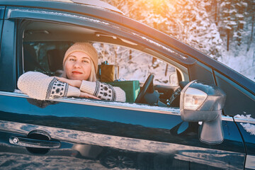 Woman Giving Gifts. Female is holding presents and delivering them on her car to Home. Holidays concept. Driving car in Christmas Eve. People In A Snow-Covered Forest. Sunny Cold Winter Day.
