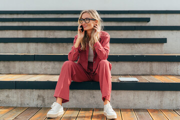 Canvas Print - Young business woman talking on a mobile phone outside.