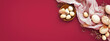 Easter banner with eggs and napkin on dark red backround. Top view, flat lay, holiday card on viva magenta color.