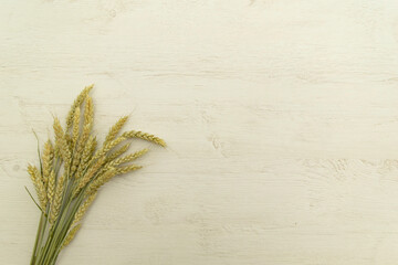 Bunch wheat ear and flour on white wood table.