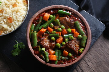 vegetable casserole with meat served with fresh salad on a black tray