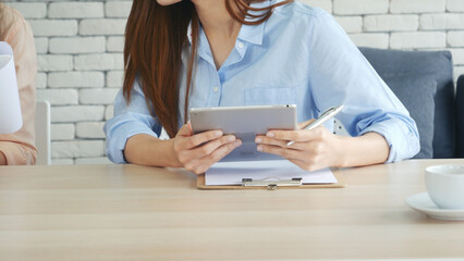 Sticker - Asian Female freelance using laptop at home office desk. Woman reading financial graph chart Planning analyzing marketing data. Asian female people working office firm with business stuff, coffee cup