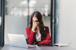 © PaeGAG - Stressed businesswoman overworked. Tired lady having headache sitting indoors..