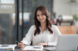 © PaeGAG - Happy smiling Asian businesswoman working and looking at the camera in office room.