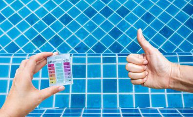 Sticker - Swimming pool water tester test kit in girl hand over crystal clear water with blue tile floor, summer outdoor day light, good quality tester