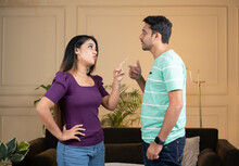 Focus On Girl, Angry Indian Couple Fighting By Shouting Eachother While Standing At Home - Conept Of Relationship Problems, Conflict And Disagreement.