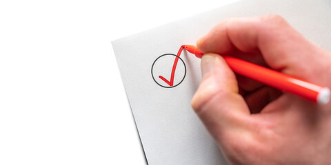 Abhaken einer Liste mit rotem Stift vor weißem Hintergrund mit Textfreiraum