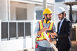 © Platoo Studio - Teamwork men in construction site, Two civil engineer in safety helmet hard hat using digital tablet and blueprint working while standing at factory.