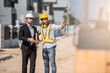 © Platoo Studio - Teamwork men in construction site, Two civil engineer in safety helmet hard hat using digital tablet and blueprint working while standing at factory.
