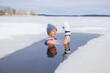 Leinwandbild Motiv Winter swimming. Woman in frozen lake ice hole. Swimmers wellness and endorphin booster swim in cold water. Beautiful female body tempering Cold winter morning landscape. Biohacking routine