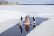 Leinwandbild Motiv Winter swimming. Woman in frozen lake ice hole. Swimmers wellness and endorphin booster swim in cold water. Beautiful female body tempering Cold winter morning landscape. Biohacking routine