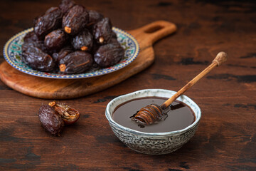 Natural date syrup in a bowl with whole dates in the background