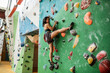 © Caia Image - Woman with headphones on climbing wall