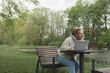 © uaPieceofCake - Woman working out of office in the park near the river. Concept of remote work at any time and place