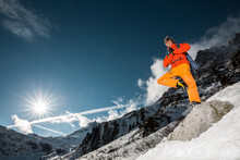 Ice Climber Standing On One Leg In Snowy Mountains Of Austrian Alps, Felbertauern, Salzburg, Austria