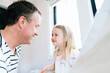 © Cavan Images - Cropped view of a father and daughter smiling at each other indoors