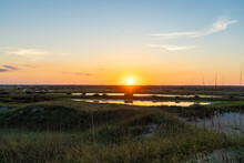 View Of The Sunset On Hatteras Island Seen Across A Tidal Marsh Near The Beach