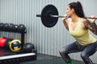 © Cavan Images - Woman weightlifting with barbell in gym