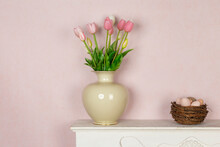 Easter Still Life With Tulips Flowers In Vase And Bird Nest With Eggs On A Rustic Vintage White Wooden Fireplace - Composition On A Pastel Pink Painted Wall Background