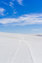 Tire Tracks On White Sand Dunes Against Blue Sky During Sunny Day
