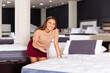 © JackF - Latin American saleswoman offering new model of modern orthopedic comfortable mattresses in furniture store