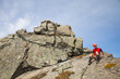 © Cavan Images - A climber down climbs a rocky summit.