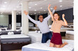 © JackF - Portrait of young latin american couple delighted with new mattress bought in furniture showroom. Successful purchase concept