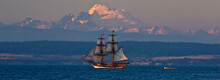 Nineteenth Century Replica Ship, Hawaiian Chieftain, Sets Sail In Penn Cove, Washington, USA At Sunset With Mount Baker In The Distance.