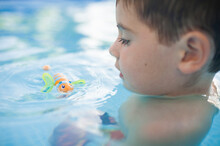 Close-up Of Boy Playing With Toy In Wading Pool