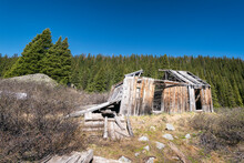 Low Angle View Of Abandoned Log Cabin Against Clear Blue Sky