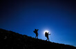 © Cavan Images - Man and woman hike / backpack down hill on a mountain ridge Kirkwood, California