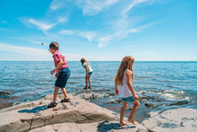 Three Children Explore A Rocky Outcrop On Lake Superior