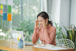© Marc Tran/Stocksy - Unhappy young asian female employee feel stressed at workplace