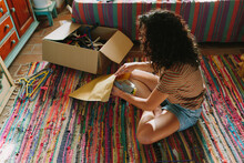 Young Woman Packing Used Clothes For Sell