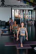 © Diane Durongpisitkul/Stocksy - People taking a cross-mat yoga class