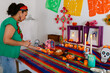 © ByLorena/Stocksy - Mexican putting candles at offerings altar