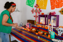 Mexican Putting Candles At Offerings Altar