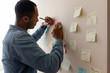 © Demetr White/Stocksy - man writing a reminder on a sticky note