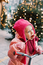 Girl In Pink Winter Clothes Eats White Chocolate Strawberry Outside