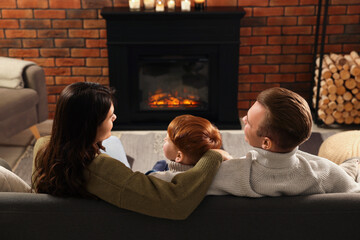 Sticker - Family spending time together on sofa near fireplace at home, back view