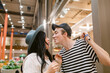 © ByLorena/Stocksy - Couple having fun eating noodles in food court